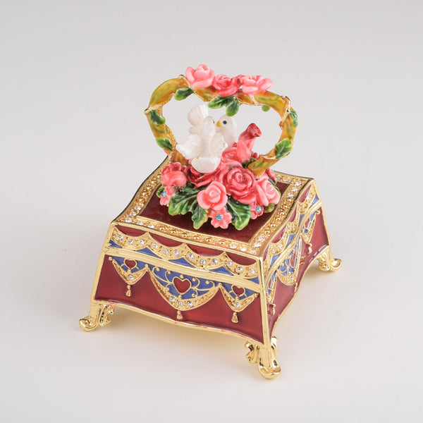 Boîte rouge décorée avec des roses et deux colombes blanches
